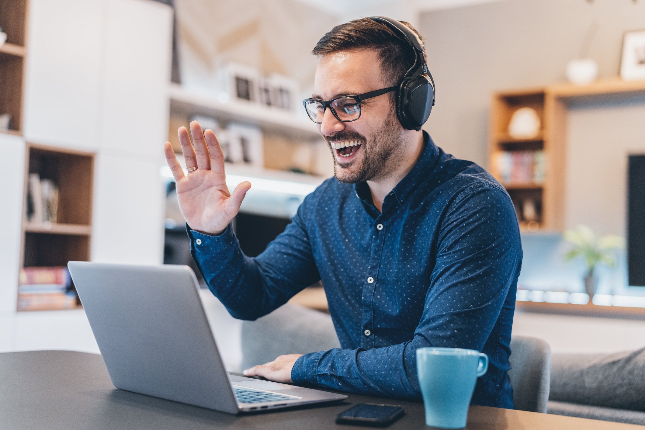 Corporate language training online: smiling man with headphones and laptop engaging in virtual language learning session to maximize ROI