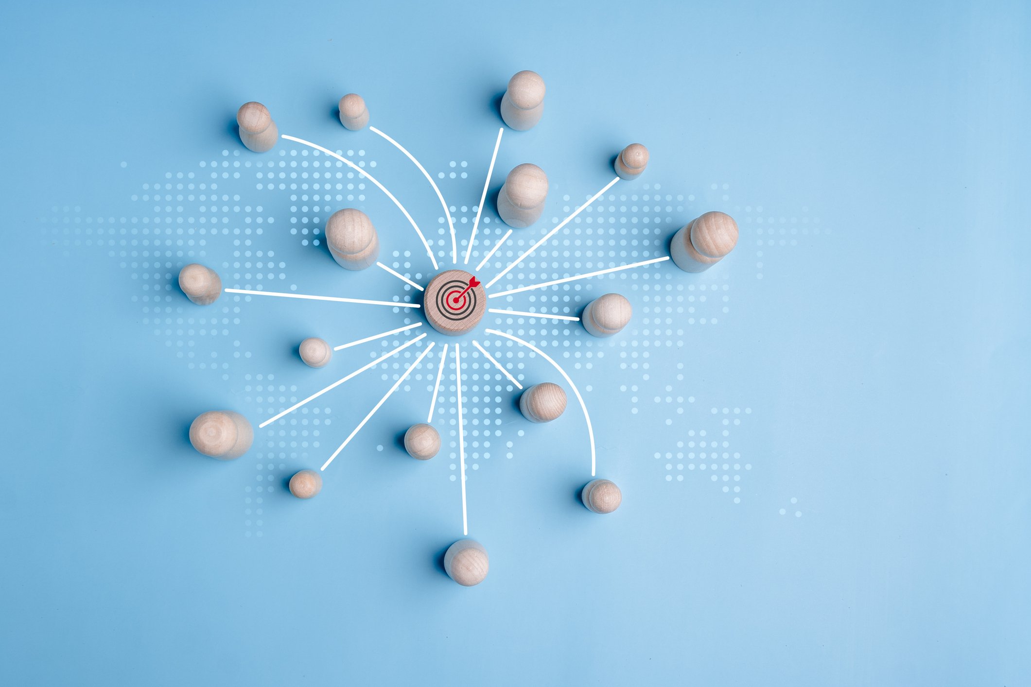 Global corporate language training network: wooden figures connected to a central target symbolizing international employee learning and maximizing ROI
